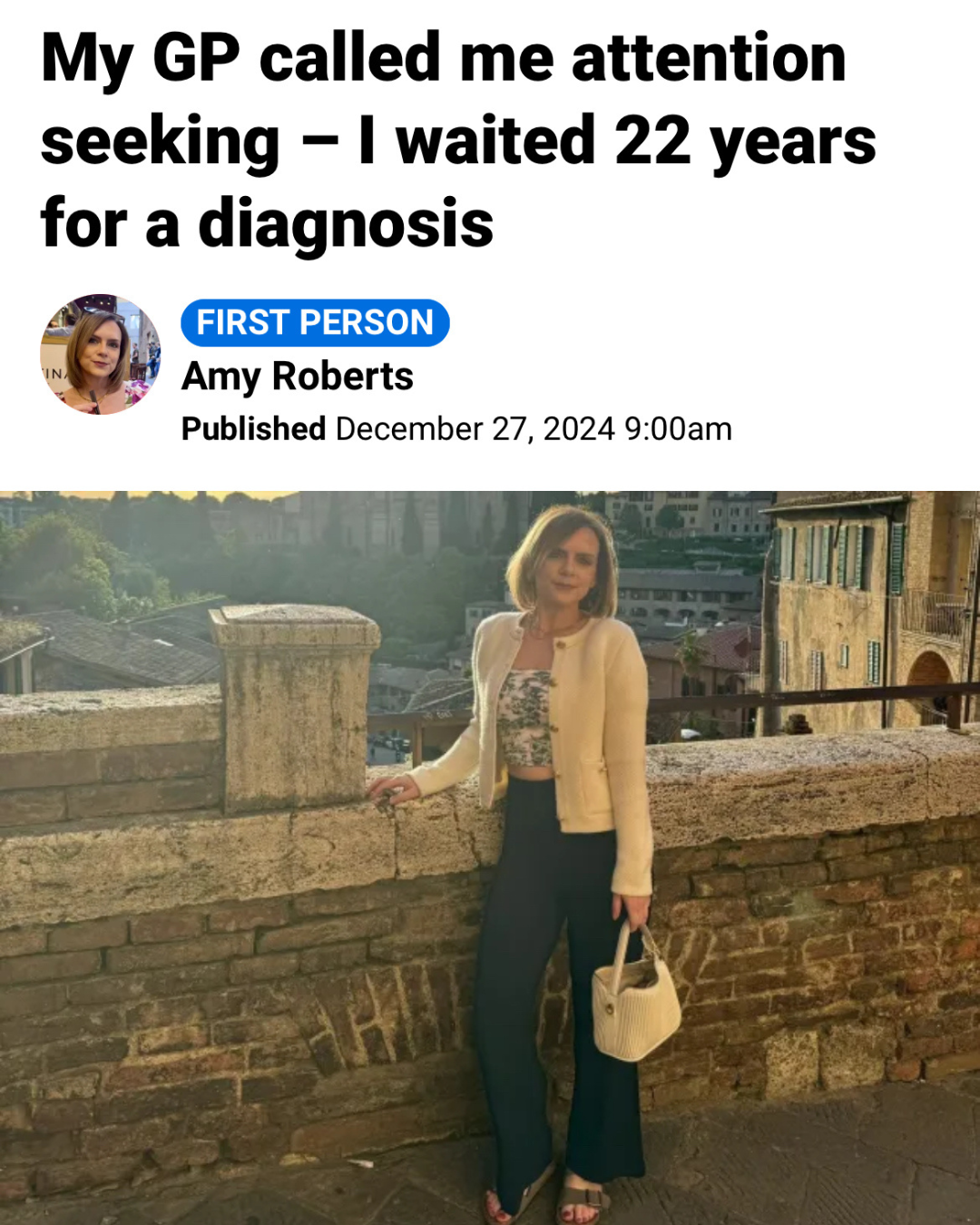 Screenshot of an online article with the headline: “My GP called me attention seeking – I waited 22 years for a diagnosis”. The article is labelled “First Person” and includes the byline “Amy Roberts” with a publication date of 27 December 2024. Below the headline is a photograph of a person standing beside a stone wall in a historic city setting, wearing a light-coloured cardigan, patterned top and dark trousers, and holding a handbag. Historic buildings and a cityscape appear in the background.