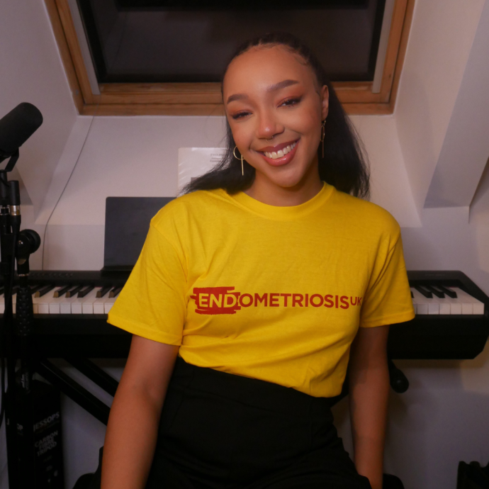 Hannah standing smiling wearing an Endometriosis UK t-shirt.