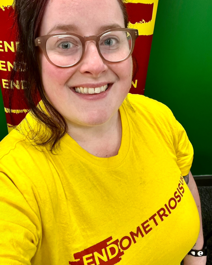 Michelle smiling wearing a yellow Endometriosis UK t-shirt