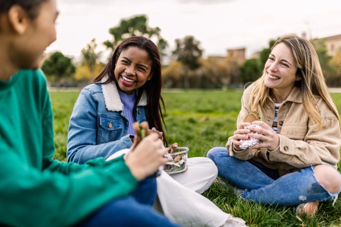 Three people sat together in a park