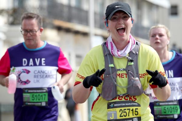 Woman smiling whilst running Brighton Marathon. 