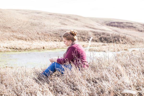 A woman sits in a field