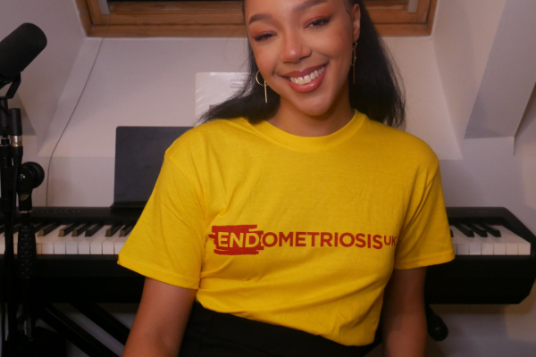 Hannah standing smiling wearing an Endometriosis UK t-shirt.