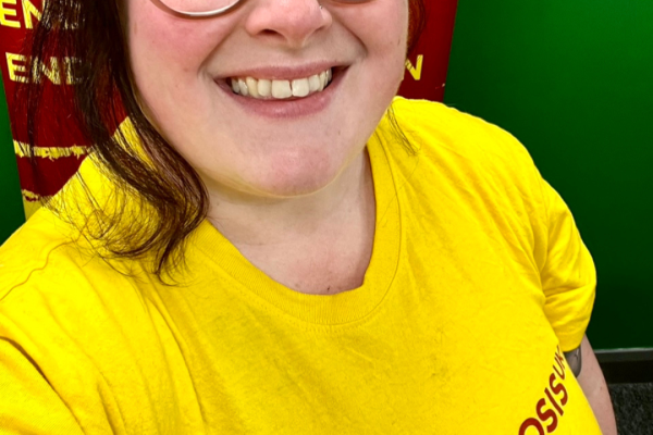 Michelle smiling wearing a yellow Endometriosis UK t-shirt