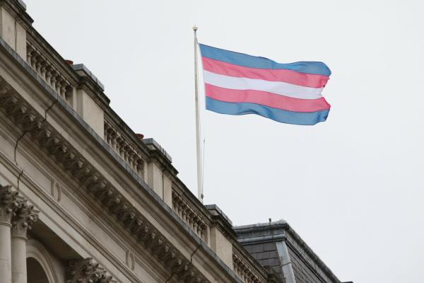 The trans pride flag flies above a building in London
