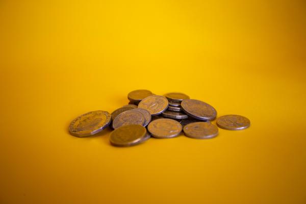 A pile of coins on a yellow background