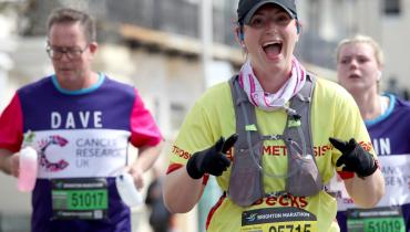 Woman smiling whilst running Brighton Marathon. 