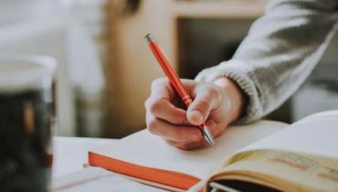 A person writing with a pen