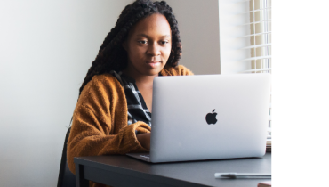 A woman looking at a laptop screen