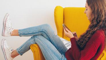 Woman sits on a yellow chair