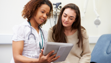 A photo of a young woman and a doctor looking over notes
